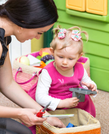 Mother and child girl playing in kindergarten in Montessori Mother and child girl playing in kindergarten in Montessori preschool Class.